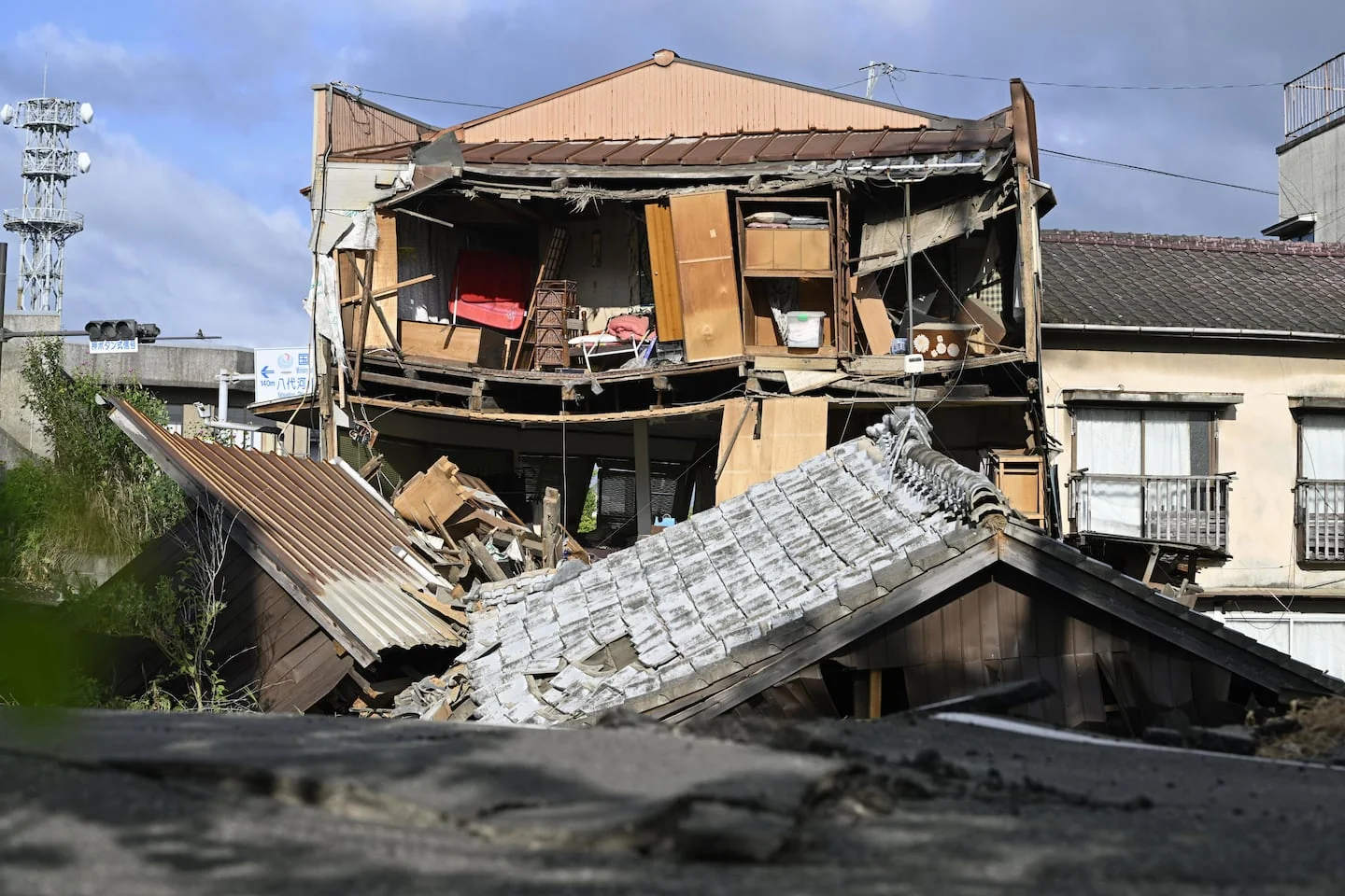 Зруйнований двоповерховий будинок після землетрусу в Кумамото з виставленими меблями