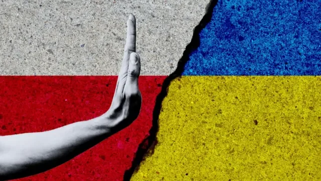 Рука в жесті стоп між прапором Польщі та України на тлі нападів