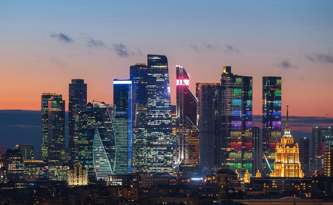 Нічний краєвид Москви з освітленими хмарочосами Москва-Сіті та сталінською висоткою